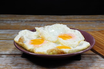 Pile of fried egg serving on the plate. Famous breakfast menu in restaurant. 