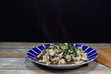 Traditional fried spicy minced pork with basil serving on the plate. Famous street food menu in Thailand. 