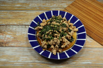 Traditional fried spicy minced pork with basil serving on the plate. Famous street food menu in Thailand. 
