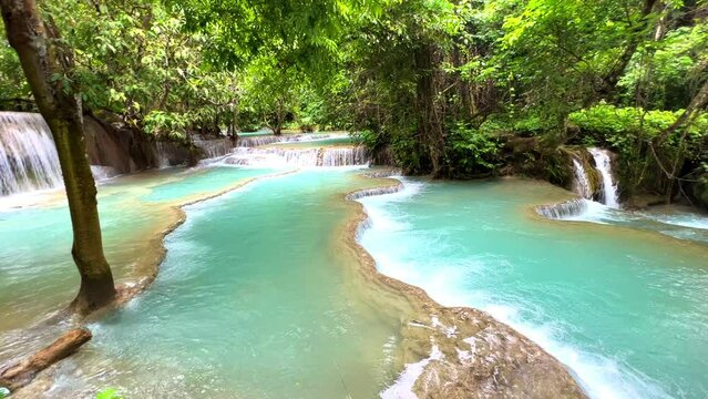 Turquoise blue colours of Kuang Si waterfalls Luang Prabang Laos. these waterfalls in the Mountains of Luang Prabang Laos flow all year round in the natural rainforest 