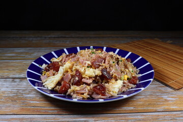 Traditional fried rice with egg and pork sausage serving on the plate. Famous street food menu in Asia. 
