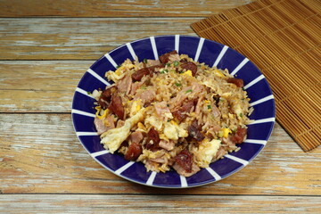 Traditional fried rice with egg and pork sausage serving on the plate. Famous street food menu in Asia. 