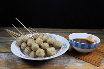 Pile of grilled pork ball serving on the plate. Famous street food menu in Asia. 