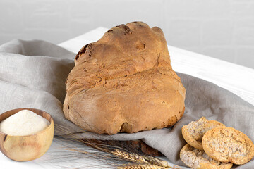 The bread of Matera, Pane di Matera on white wooden background, typical southen italian sourdough bread, the crunchy loaf has the shape of a croissant and is produced with durum wheat semolina