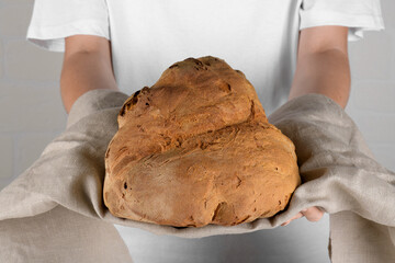 Female hands holding the bread of Matera, Pane di Matera on white background, typical southen...