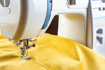 Modern sewing machine presser foot with linen fabric and thread, closeup, copy space. Sewing...