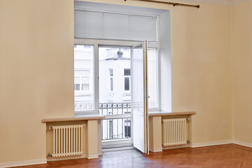 A spacious hall in the house with large doors and access balcony.