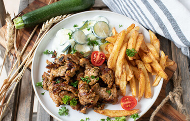 Fried pork with homemade french fries and zucchini salad on a plate