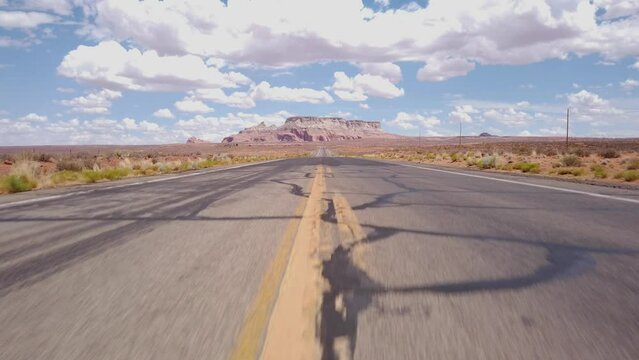DOLLY SHOT - State Route 98 in Coconino County of northern Arizona, USA. Empty desert road with the LeChee Rock in the background.