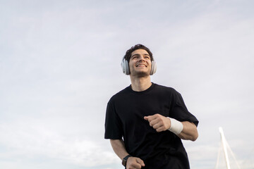 Runner male athlete running does a workout exercise in the city, uses a fitness watch