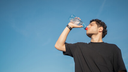 Drinking clean water quenches thirst, a male athlete runner does a workout.