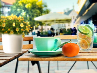  summer street cafe glass of lemon orange water ,cup of coffee and flowers on wooden table in Tallinn old town vacation travel holiday in Estonia 