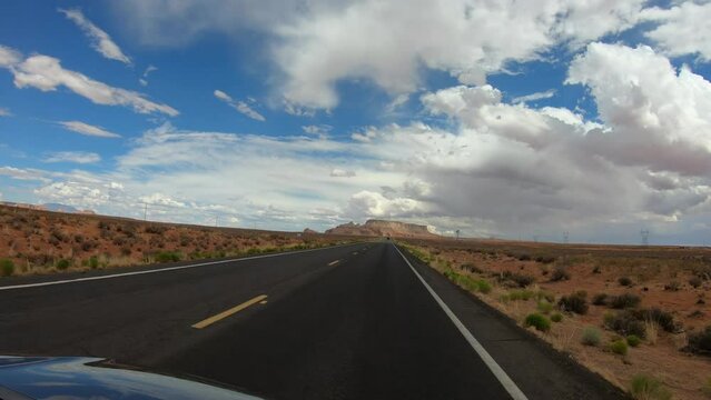 Page, Arizona, USA, June 23, 2022: TRAVELING CAR SLOW MOTION - Drive through Highway 98, from the northwest, with the LeChee Rock in the background.