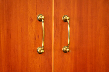 Metal handles on wooden cabinet.