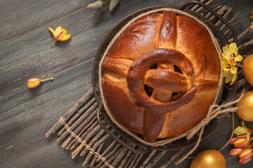 Portuguese traditional Easter cake. Folar with golden eggs on easter table. Blossom flowers and golden painted eggs.
