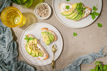 Healthy toast with avocado cream cheese and wheat bread on a plate. Delicious snacks and avocado sandwiches. Food composition, tasty Italian meal.