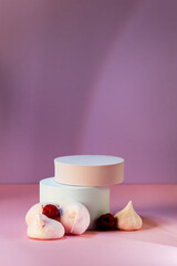 Composition with Three Empty Geometric Podium with Merengue Cookies and Raspberry on Pink Background. Banner concept Vertical