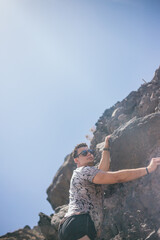 Obraz premium handsome young Latin climbing volcanic mountain