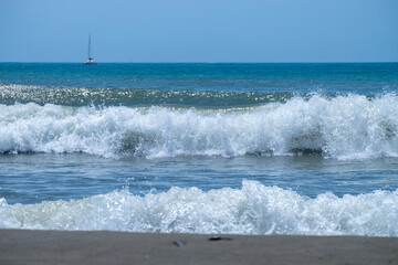 Ocean waves crashing on sandy beach. Sea waves breaking on Maditerranean's shore.