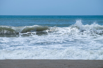 Ocean waves crashing on sandy beach. Sea waves breaking on Maditerranean's shore.