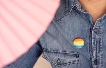 man with rainbow pin lgtbiq collective symbol, close up
