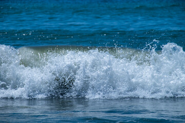 Ocean waves crashing on sandy beach. Sea waves breaking on Maditerranean's shore.