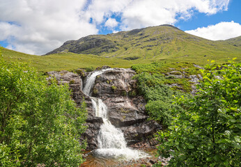 The Meeting of the Three Waters, Glencoe. The waterfall is situated at the foot of the Three Sisters of Glen Coe - a popular hiking and skiing area.  - obrazy, fototapety, plakaty