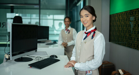 Portrait of beautiful Asian woman airport ground attendant in uniform and standing smile at counter...