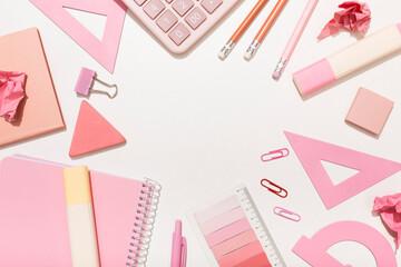 School supplies in pink colors on a white background with a place for an inscription. Preparation for school