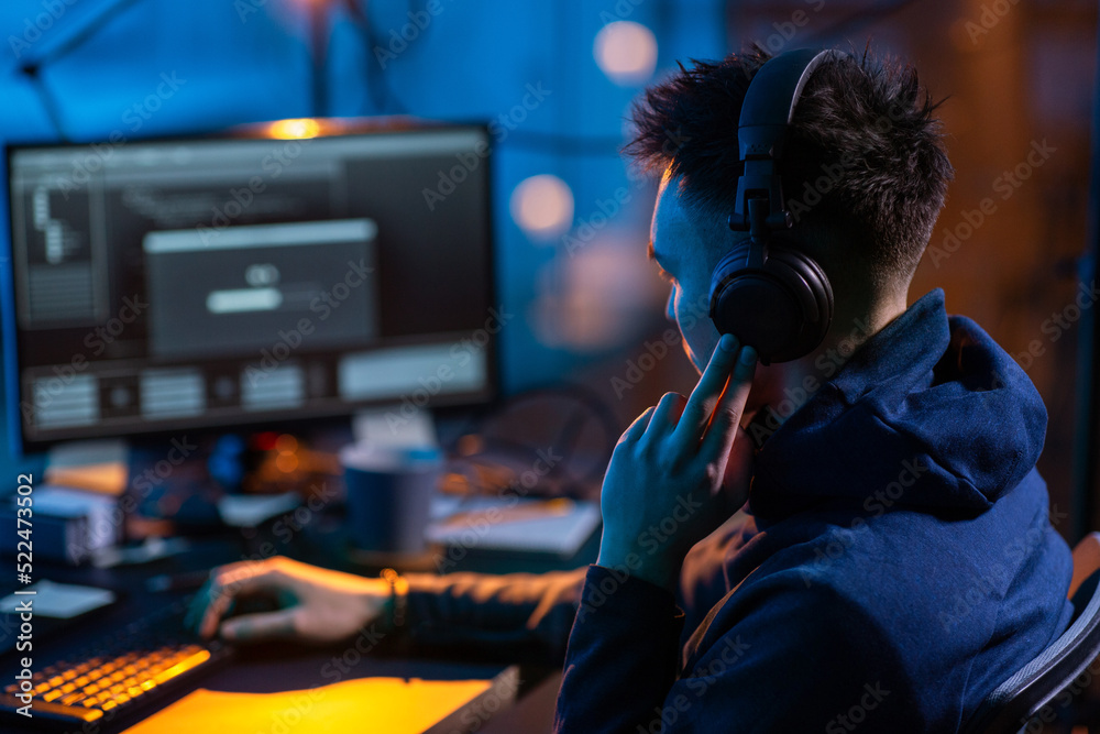 Poster cybercrime, hacking and technology concept - close up of male hacker in dark room writing code or us
