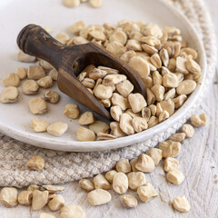 Scoop of raw dry Grass pea close up on wooden table. Legumes known in Italy as Cicerchia