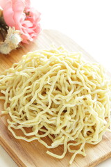 Chinese food, egg noodles on wooden chopping board