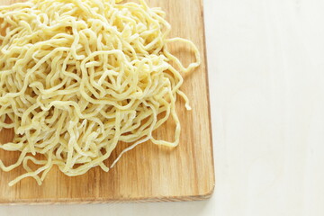 Chinese food, egg noodles on wooden chopping board