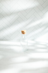 Fototapeta na wymiar Glass bottled water in kitchen shadows