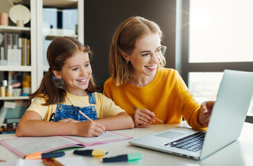 Fototapeta na wymiar Cheerful mother doing homework with daughter at home