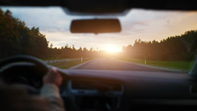 Driving car in summertime on the sunset.