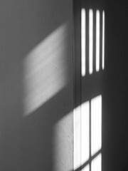 light from the window on white wall with shadow in the dark room - 522486339