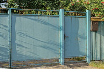blue metal gate and iron door on a rural fence in the street