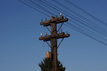 one gray old wooden electric pole without wires against a blue sky
