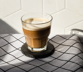 cortado coffee in a glass cup. Hard shadows from a scan with coffee in a cafe. Spanish coffee	