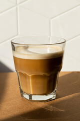 cortado coffee in a glass cup. Hard shadows from a scan with coffee in a cafe. Spanish coffee	
