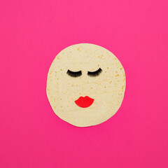 Tortilla with fake eyelashes and red lips isolated on pink background. Street fast food or make up industry. 