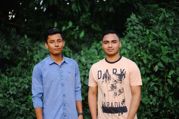 Young south asian friends standing together  in a natural environment wearing casual dresses ,...