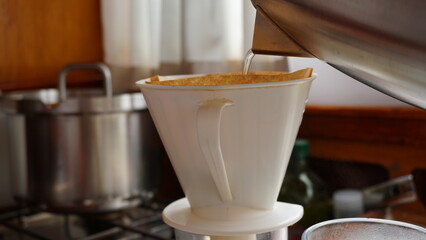 Freshly brewed coffee with a separate filter and pour in water. Fresh morning drink with blackened caffiene to which sugar and milk may have been added. Energy boost.