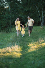 Naklejka na ściany i meble family walk with children in the park near the pond and animals