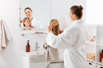 beauty, hygiene, morning and people concept - happy smiling mother and little daughter with...
