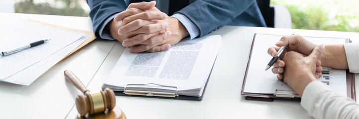 Legal counsel presents to the client a signed contract with gavel and legal law. justice and lawyer concept