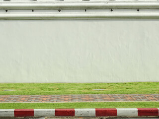 aged street white wall with walkway of footpath on the lawn