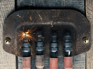 First Advent background with four spark plugs on rusty sign, car workshop advent