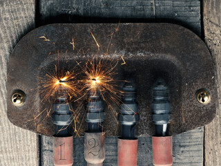 Second Advent background with four spark plugs on rusty sign, car workshop advent